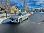2019 Hyundai Ioniq Electric parked on a snow-covered street, showcasing its sleek design and low mileage.