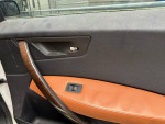 Interior detail of a 2006 BMW X3 door with leather accents and window control