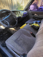 Interior view of a 1998 Dodge Ram 1500 truck showing seats and dashboard, 160k miles, functional and well maintained.