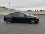 Side view of a black 2017 Chrysler 300 S with a sleek design, parked in a residential area.
