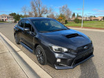 2018 Subaru WRX in grey with manual transmission parked on a sunny street.