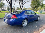 2006 Chevrolet Impala SS in blue, showcasing its sleek design parked in a leafy area, with 56,000 miles.