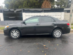 Side view of a 2012 Toyota Corolla LE FWD parked, showcasing its sleek design and features.