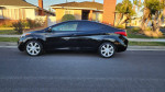 2013 Hyundai Elantra Limited in black parked on a street, showcasing its sleek design and clean condition.