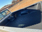 View of the truck bed in a 1992 Ford F-150 with a bed liner and storage bins.