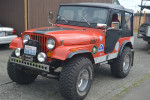 1974 Jeep CJ5 in vintage orange color, equipped with off-road features and raised suspension.