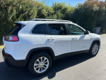 2019 Jeep Cherokee Latitude FWD parked in a sunny area, showcasing its sleek design and spacious trunk.