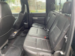 Interior view of 2014 Ford F350 SuperDuty with black leather seats and spacious back area.