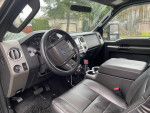 Interior view of 2014 Ford F350 Super Duty with black leather seats and modern dashboard features