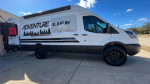 2017 Ford Transit 250 custom motovan with off-road tires and electric awning, designed for adventure and motorcycle storage