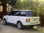 2012 Land Rover Range Rover Supercharged parked in a garden with trees, showcasing a clean white exterior.