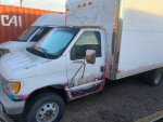 2002 Ford E-350 box truck with lift gate, white exterior and dual rear wheels, ideal for work and transport.