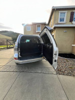 Lexus GX 460 Luxury Edition with open rear door parked in driveway, showcasing spacious interior.