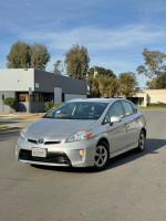 2015 Toyota Prius Package 2 parked on the street, showcasing its sleek design and hybrid efficiency.