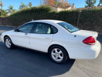 2004 Ford Taurus SES white car, clean title, low mileage, V6 engine, parked with greenery in background