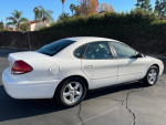 2004 Ford Taurus SES in white, showcasing its clean exterior and good condition, parked in a sunny area.