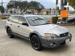 2005 Subaru Outback with low mileage, all-wheel drive, and clean title parked in an urban setting.