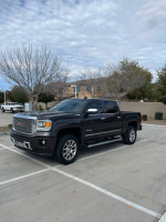 2015 GMC Sierra Denali Z71 in black parked, highlighting premium features and modern design