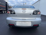 Back view of a silver Mazda 3 with low mileage of 102,000 miles, showcasing its sleek design.