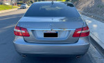 2012 Mercedes-Benz E350 Sport Sedan in Palladium silver metallic parked on the street, showcasing its clean exterior and alloy wheels.