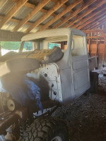1970s Ford truck chassis with interior work in progress, parked in a rustic barn setting.