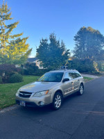 2008 Subaru Outback 2.5 XT Limited AWD in gold, parked on a street with trees.