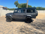 1994 Land Rover Defender 110 with V8 engine, manual transmission, parked in a sunny outdoor setting.