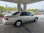 2000 Toyota Camry LE FWD parked under a canopy, showcasing its silver exterior in good condition.