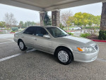 2000 Toyota Camry LE sedan parked outside, showcasing its silver exterior and low mileage of 62,000 miles.