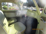 Interior of a classic Volkswagen Bug with green upholstery and vintage dashboard.
