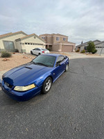 2004 Ford Mustang in blue, 91,000 miles, selling for $4,200, needs exhaust work and has minor damage.