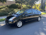 2008 Toyota Prius Package 6 in black, showcasing its sleek design and parked on a residential street.