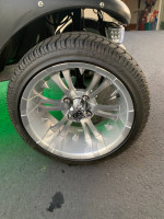 Close-up of a sleek silver wheel on a custom-built Club Car Precedent golf cart with sport design