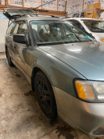2002 Subaru Outback with low mileage and new all-season tires, parked indoors with good overall condition.