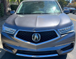 Front view of a silver 2020 Acura MDX with salvage title, showcasing its sleek design and clean condition.