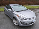 2015 Hyundai Elantra in silver with winter tires on a rainy day, showcasing a sleek design and great mileage.