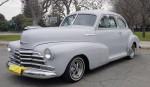 Classic 1947 Chevy Fleetmaster coupe in primer gray, showcasing elegant design with chrome accents.