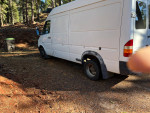 2004 Dodge Sprinter 3500 van parked in a forest area, showing wear and tear with 113k miles.