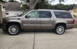 2012 Cadillac Escalade ESV Luxury in bronze color, parked outside, showcasing its sleek design and alloy wheels.