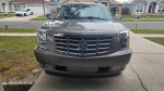 Front view of a 2012 Cadillac Escalade Luxury SUV in bronze color, showcasing its distinctive grille and headlights.