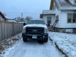 2016 Ford F-350 Supercab 4x4 parked in snowy driveway, showcasing enclosed service body and rugged design.