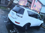 2010 Mitsubishi Outlander in white, parked with winter tires, spacious 7-seater, ready for winter use.