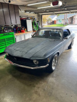 1970 Ford Mustang Coupe parked in a garage, featuring a sleek design and upgraded performance parts.