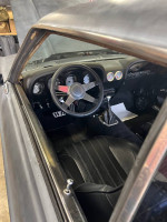 Interior view of a 1970 Ford Mustang Coupe featuring a modern dashboard and steering wheel.