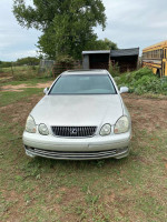 2002 Lexus ES 300 parked on grass, showcasing its exterior with minor wear and tear, ideal for car enthusiasts.