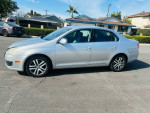 2024 Volkswagen Jetta in silver, showcasing its sleek design, parked on a sunny day.
