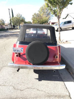 Rear view of a restored 1950 Willys Jeepster with a convertible top and modern upgrades.