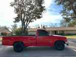 1993 Toyota T100 SR5 4WD in red, good condition, parked on street with long bed and new all-terrain tires