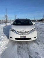 2015 Toyota Sienna LE AWD van in snowy landscape, clean and well-maintained, ideal for winter driving.