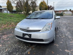 2006 Toyota Prius in silver color, low mileage, parked on asphalt with clean exterior.